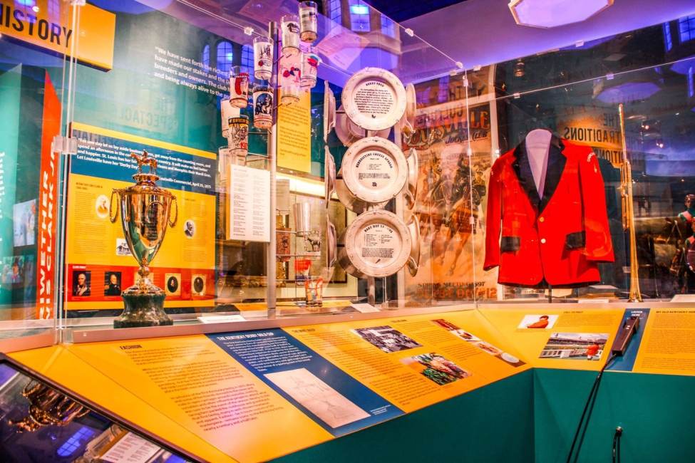 An exhibit displaying trophies and a riding outfit.